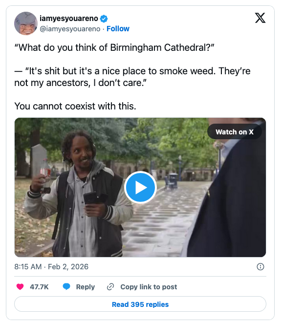 A person standing outdoors, holding a drink and gesturing while speaking. They are dressed casually in a light jacket, with a blurred background of a park-like setting.