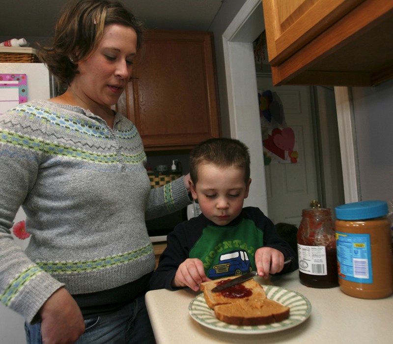 Carter, son of Eleana Walsh, makes a peanut butter and jelly sandwich. AP Images