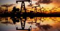Pump jack silhouette against a sunset sky with reflections in the water