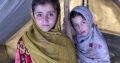 Two young Muslim girls, wearing traditional headscarves in a tent